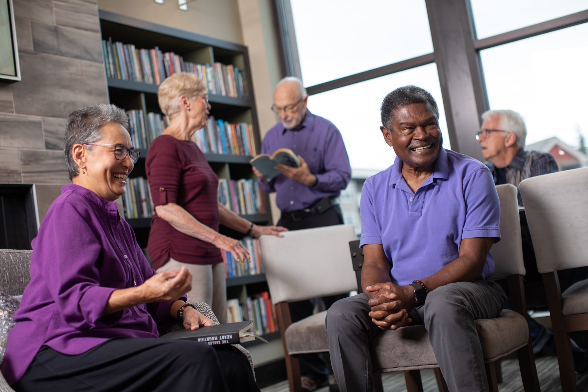 members of a senior living community book club reading and laughing